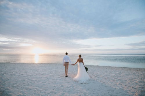 Mariage à l'étranger - mariés sur la plage main dans la main