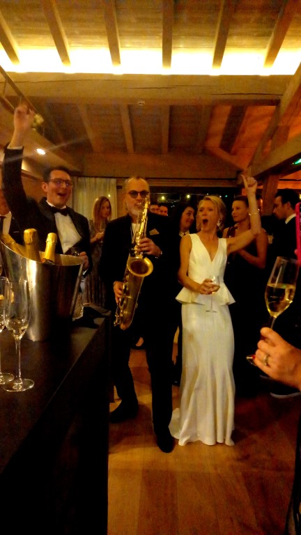 couple de mariés avec un saxophoniste pendant le vin d'honneur de leur mariage de rêve